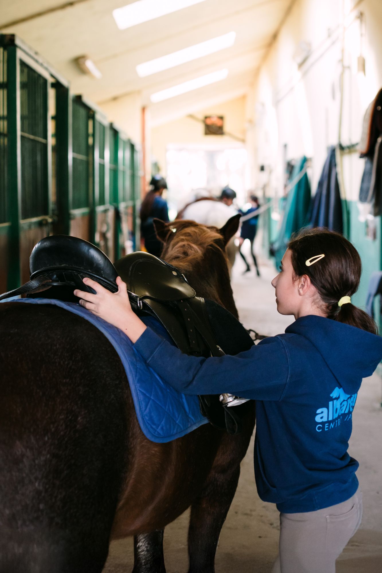 Allieva che si prende cura del cavallo in scuderia